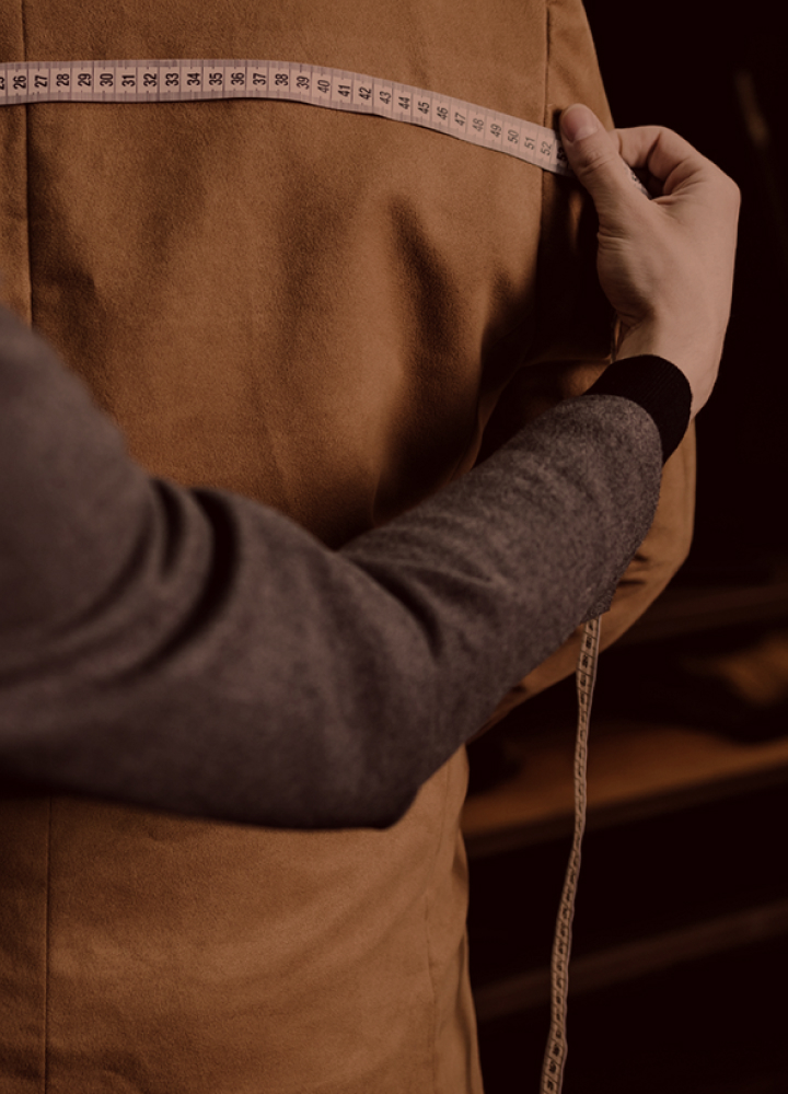 後ろからジャケットの肩幅のサイズを測っている様子